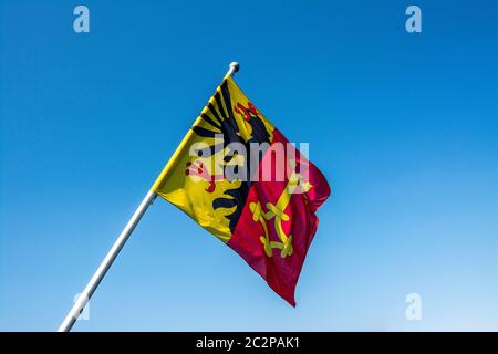 Die Genfer Flagge winkt stolz gegen einen klaren blauen Himmel in der Schweiz Stockfoto