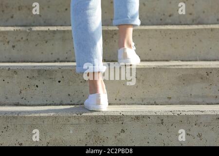 Rückansicht Nahaufnahme der Beine einer Frau, die Turnschuhe trägt, die eine Treppe hoch gehen Stockfoto