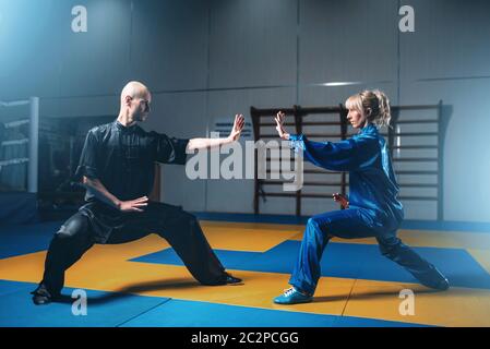 Männliche und weibliche Wushu-Kämpfer Übungen indoor, Martial-Arts. Sparring-Partner in Aktion Stockfoto