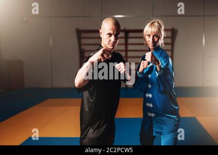 Wushu-Kämpfer, männliche und weibliche Partner Posen indoor, Martial-Arts-Kultur Stockfoto