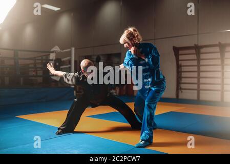 Männliche und weibliche Wushu-Kämpfer Übungen indoor, Martial-Arts. Sparring-Partner in Aktion Stockfoto