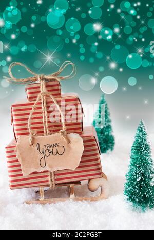 Schlitten mit Weihnachtsgeschenk und Label mit englischen Kalligraphie Danke. Schnee mit Weihnachtsbaum und Grün funkelnden Hintergrund Stockfoto