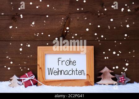 Rahmen mit Deutschen Kalligraphie Frohe Weihnachten bedeutet, frohe Weihnachten. Weihnachtsdekoration wie Geschenk, Baum und Stern. Holz- Hintergrund mit Schnee Stockfoto
