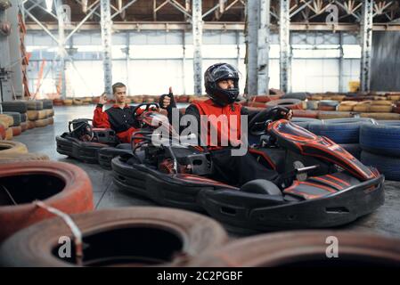 Zwei Kart-Rennfahrer, Kart Auto Sport Indoor. Speed Race auf engem Go-Kart Track mit Reifenbarriere. Schnelle Fahrzeug-Wettbewerb, aktives Hobby Stockfoto