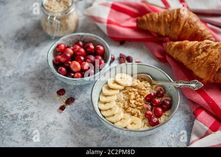 Keramische Schüssel Haferflocken Haferflocken mit Banane, frische Preiselbeeren und Walnüsse Stockfoto