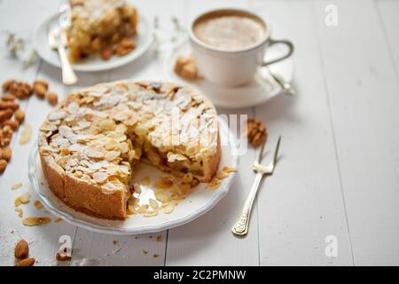 Ganze Apfel Kuchen mit Mandeln auf hölzernen Tisch serviert Stockfoto