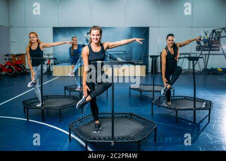 Frauen Gruppe tun fit Übung auf Sport Trampolin, Fitness-Workout. Weibliche Teamarbeit im Fitnessstudio. Aerobic-Kurs Stockfoto