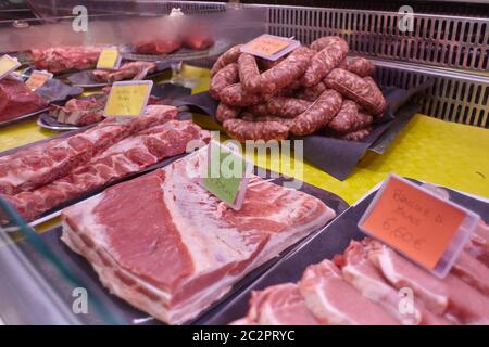 Rohes Kalbsfleisch in einer kalten Theke mit Preisschildern zum Verkauf in der Metzgerei angezeigt. Stockfoto
