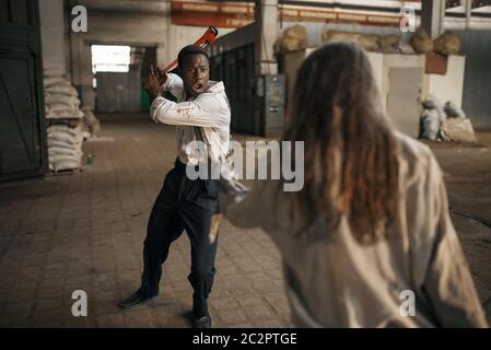 Weibliche Zombie kämpft mit hoffnungslosen Mann in verlassenen Fabrik. Horror in der Stadt, gruselige Krabbeltiere, Weltuntergangsapokalypse, blutige böse Monster Stockfoto