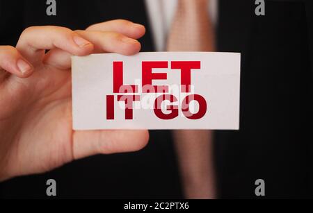 Closeup auf Geschäftsmann hielt eine Karte mit Text LET IT GO, Firmen-Konzept-Image mit soft-Fokus-Hintergrund und Vintage-Ton Stockfoto