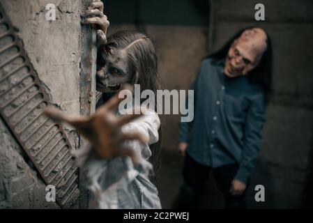 Zombie-Paar in verlassenen Fabrik, Teufel Familie. Horror in der Stadt, gruselige Krabbelangriffe, Weltuntergangsapokalypse, blutige böse Monster Stockfoto