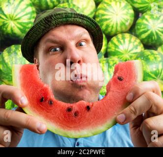 Bizarre Mann isst Wassermelone im Freien im Sommer Stockfoto