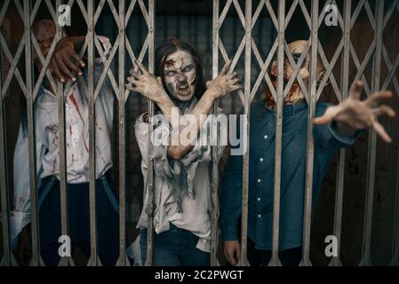 Zombie hinter den Gittern des Aufzugs, Todesfalle, tödliche Verfolgungsjagd. Horror in der Stadt, gruselige Krabbelangriffe, Weltuntergangsapokalypse, blutige Monster Stockfoto