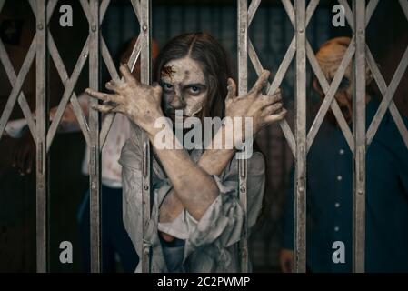 Zombie hinter den Gittern des Aufzugs, Todesfalle, tödliche Verfolgungsjagd. Horror in der Stadt, gruselige Krabbelangriffe, Weltuntergangsapokalypse, blutige Monster Stockfoto