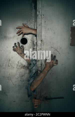 Zombie Hände ragen aus der Aufzugstür, tödliche Verfolgungsjagd. Horror in der Stadt, gruselige Krabbelangriffe, Weltuntergangsapokalypse, blutige Monster Stockfoto