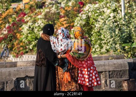 Nagpur, Maharahstra, Indien - März 2019: Rückprofil von drei jungen indischen muslimischen Mädchen in schwarzen und bunten Blumen-Hijabs. Stockfoto