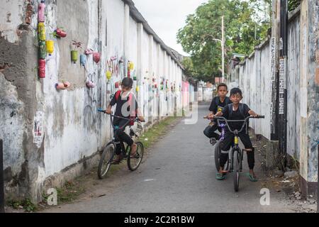 Mataram, Lombok, Indonesien - 21. August 2017: Einheimische Kinder fahren auf der Straße von Mataram, Indonesien, Fahrräder. Stockfoto