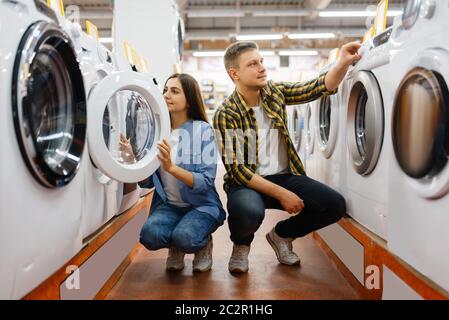 Familie Paar Wahl Waschmaschine in Elektronik-Geschäft. Mann und Frau kaufen elektrische Haushaltsgeräte auf dem Markt Stockfoto