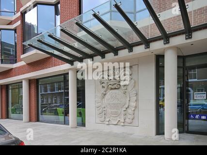 Eingang zum neuen Gebäude der Royal National ENT and Eastman Dental Hospitals in der Eastman Street, London, Großbritannien. Zeigt original Steinwappen. Stockfoto