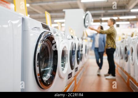 Familie Paar Wahl Waschmaschine in Elektronik-Geschäft. Mann und Frau kaufen elektrische Haushaltsgeräte auf dem Markt Stockfoto