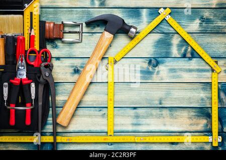 Blick von oben der Tischler Hammer und Tasche mit Arbeit Tools auf einem antiken Holztisch. Haus Konzept mit dem Messgerät. Industrie Bau- und Stockfoto