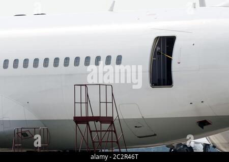 Bullaugen und eine offene Tür zu einem Passagierflugzeug, im Dienst nach dem Flug Stockfoto