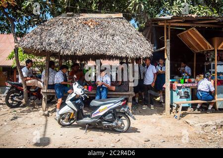 BALI, INDONESIEN - 01. Dezember 2019: Traditionelles balinesisches Stammdorf. Autos und Motorräder fahren auf der Straße in Bali, Indonesien Stockfoto