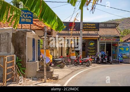 BALI, INDONESIEN - 01. Dezember 2019: Traditionelles balinesisches Stammdorf. Autos und Motorräder fahren auf der Straße in Bali, Indonesien Stockfoto