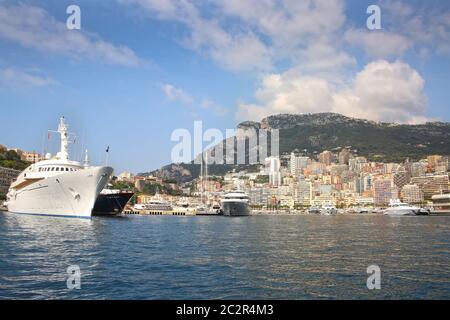 Blick vom Mittelmeer auf das Fürstentum Monaco und Monte Carlo mit seinen dichten Wolkenkratzern, dem Yachthafen, den Yachten, dem Palast und dem Casino. Stockfoto