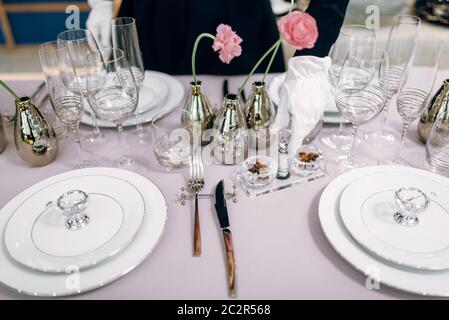 Kellnerin gegen leere Geschirr, Tisch einstellen. Mit Service, festliches Abendessen Dekoration Stockfoto