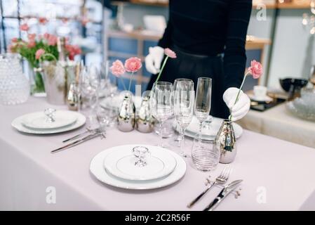 Kellnerin gegen leere Geschirr, Tisch einstellen. Mit Service, festliches Abendessen Dekoration Stockfoto