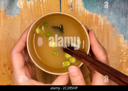 Frau essen Miso Suppe im Takeaway Cup. Der traditionellen asiatischen Küche. Stockfoto
