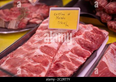 Rohes Kalbsfleisch in einer kalten Theke mit Preisschildern zum Verkauf in der Metzgerei angezeigt. Stockfoto