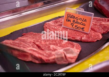 Rohes Kalbsfleisch in einer kalten Theke mit Preisschildern zum Verkauf in der Metzgerei angezeigt. Stockfoto
