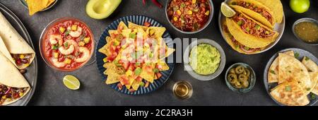 Mexikanische Küche über dem Kopf Panoramaaufnahme, viele Gerichte der Küche von Mexiko, flachliegend auf einem dunklen Hintergrund. Nachos, Guacamole, shr Stockfoto