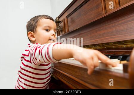 Kleiner Junge, der Klavier spielt Stockfoto