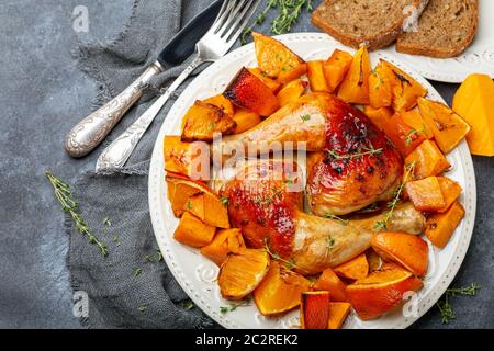 Hähnchenschenkel und gebackener Kürbis. Stockfoto