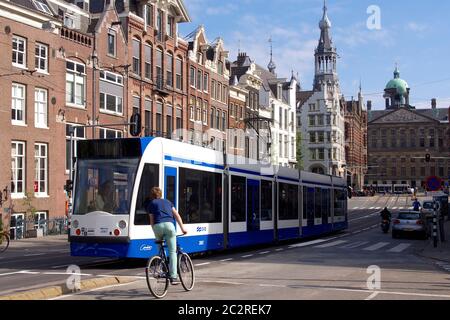 Die Straßenbahn fährt entlang der Raadhuisstraat in Amsterdam mit Radfahrern und historischen Gebäuden. Niederlande. Europa Stockfoto