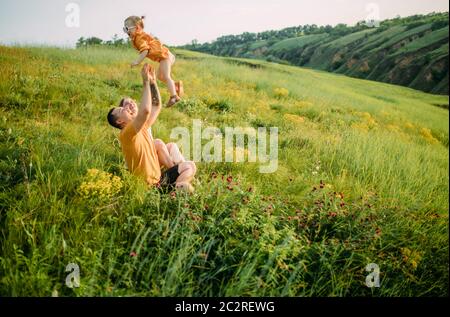 Junge Familie mit kleiner Tochter spielt, hat Spaß und lacht fröhlich. Stockfoto