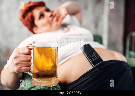 Übergewichtige Frau mit einem Glas Bier in der Hand, Fettleibigkeit. Ungesunde Lebensweise, Fettsäuren Weiblich Stockfoto