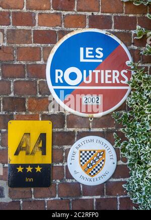 Verkehrsschilder an der White Lion Pub Wall in Wherwell, Hampshire, England, Großbritannien Stockfoto
