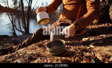 Das Thema des Tourismus ist Wandern und Reisen in der Natur. Hände EIN kaukasischer Mann verwendet Ausrüstung, um Essen draußen zu kochen. Ein Tourist ins Stockfoto