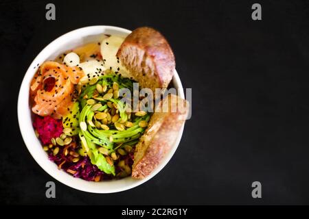 Bio-Lebensmittel. Rezept für frische Meeresfrüchte. Frische Lachsschüssel mit Reis, Ei, Brot, frischem Rotkohl, Avocado, Rettichsprossen auf Stockfoto