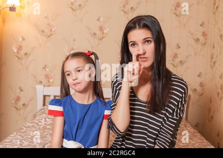 Mutter pflückt eine Nase gegen ihre hübsche Tochter. Stockfoto