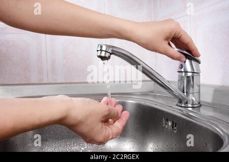 Frauen Hand drehen auf einen Wasserhahn Stockfoto