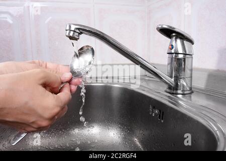 Frauenhände waschen das Geschirr im Waschbecken Stockfoto