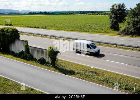 Heidelberg, Deutschland. Juni 2020. Ein Auto fährt vor einem Feld im Gaulschlag-Gebiet, einem der beiden möglichen Standorte für die neue Ankunftsstelle für Flüchtlinge, an der Bundesstraße 535. Auf dem Gelände des bestehenden Ankunftszentrums in der ehemaligen US-Siedlung Patrick-Henry-Village soll ein neuer Stadtteil entstehen. Das Ankunftszentrum soll daher an einen anderen Standort umziehen. Quelle: Uwe Anspach/dpa/Alamy Live News Stockfoto