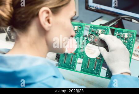 Techniker, der Komponenten auf eine Leiterplatte im Elektronikwerk lötet Stockfoto