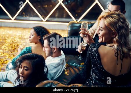 Eine Gruppe junger Freunde ist in der Nacht unterwegs und trinkt Champagner im Nachtclub Stockfoto