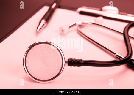 Nahaufnahme der medizinische Stethoskop auf Zwischenablage. Rot getönt Stockfoto